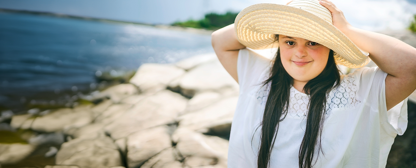 woman wearing a hat and smiling at the beach